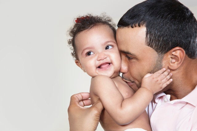 Father holding and kissing baby girl