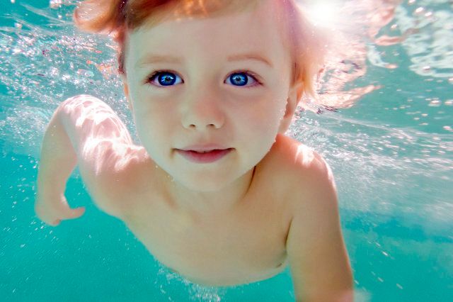 Toddler boy swimming under water