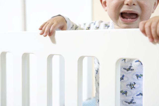 Baby boy (12-15 months) in cot, crying, close-up