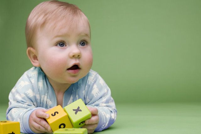 Baby holding building blocks