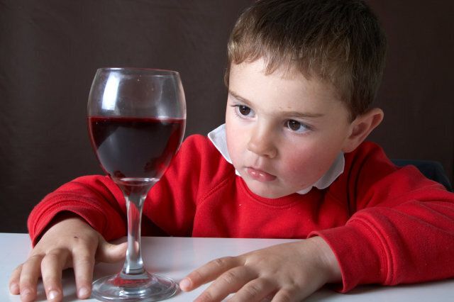Four year old boy with red wine