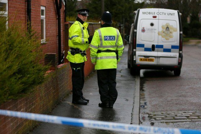 Police officers stand at the corner of Emily Street in Blackburn, Lancashire, after an eleven month old baby girl died after she was mauled by a pet dog.