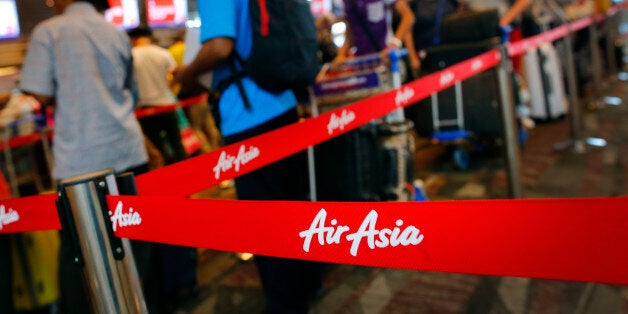 Passengers queue at AirAsia's check-in counters, at the Changi International Airport Monday, Dec. 29, 2014 in Singapore. Search planes and ships from several countries on Monday were scouring Indonesian waters over which an AirAsia jet disappeared, more than a day into the region's latest aviation mystery. AirAsia Flight 8501 vanished Sunday in airspace thick with storm clouds on its way from Surabaya, Indonesia, to Singapore. (AP Photo/Wong Maye-E)