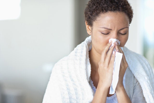 Sick woman blowing her nose