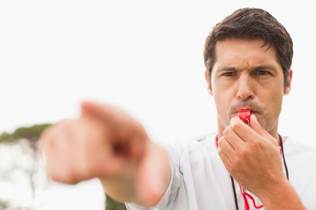 Referee blowing whistle in game