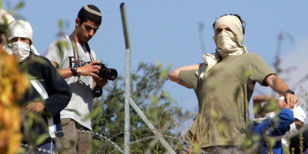 FILE: PHOTO: Israeli settlers throw stones at journalists and Palestinians near the Jewish settlement of Kharsina, north of the occupied West Bank city of Hebron, on October 31, 2008. Agence France-Presse photographer Hazem Bader suffered head injuries today when settlers hurled rocks at journalists near the occupied West Bank city of Hebron, witnesses said. In hospital Bader received eigth stitches and will stay overnight. He was among a group of journalists who had gone to the house of a Pales