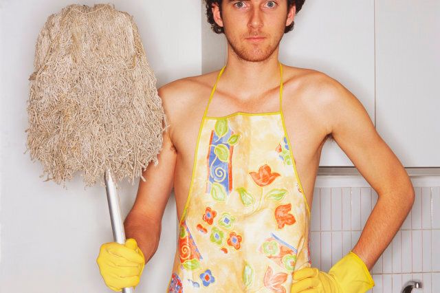 Young man with apron and mop, portrait