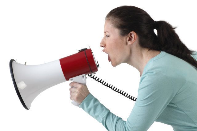 A young woman shouting into a megaphone.