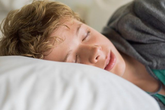 Teenage boy sleeping on the bed