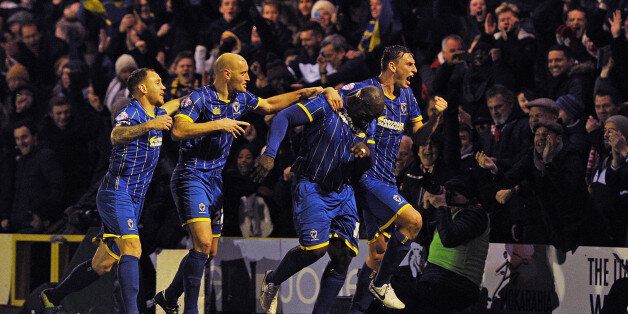 Abedayo Akinfenwa of AFC Wimbledon celebrates after scoring the equalizer during the FA Cup Third Round match bewteen AFC Wimbledon and Liverpool at The Cherry Red Records Stadium on January 5, 2015 in Kingston upon Thames, England. (Photo by John Powell/Liverpool FC via Getty Images)