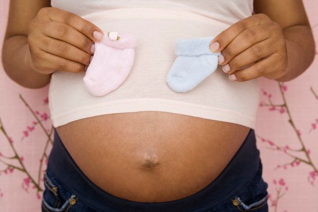 Pregnant African American woman holding booties