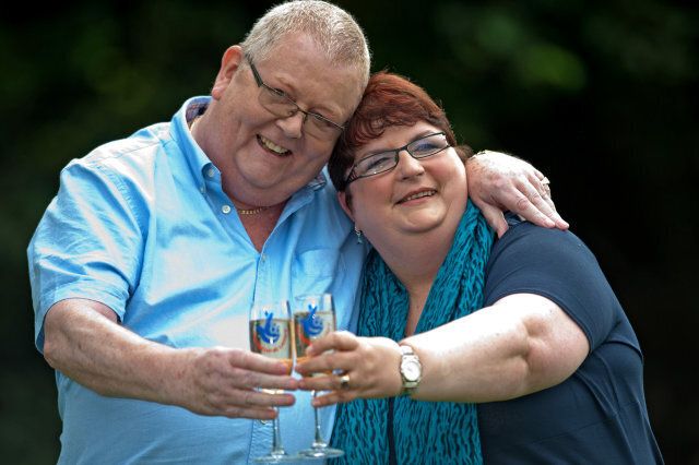 Colin Weir (L) and his wife Chris pose for pictures with champagne during a photocall in Falkirk, Scotland, on July 15, 2011, after winning a record GBP161m (184m euros/259m USD) in the EuroMillions Lottery, on July 15, 2011. The Euro Millions lottery, launched in 2004, is now played by nine countries across western Europe: Austria, Belgium, Britain, France, Ireland, Luxembourg, Portugal, Spain and Switzerland. AFP PHOTO/ WATTIE CHEUNG (Photo credit should read Wattie Cheung/AFP/Getty Images)