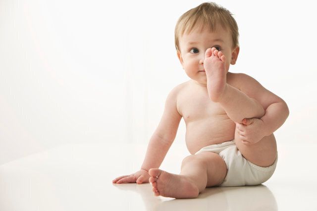 Mixed race baby boy lifting leg