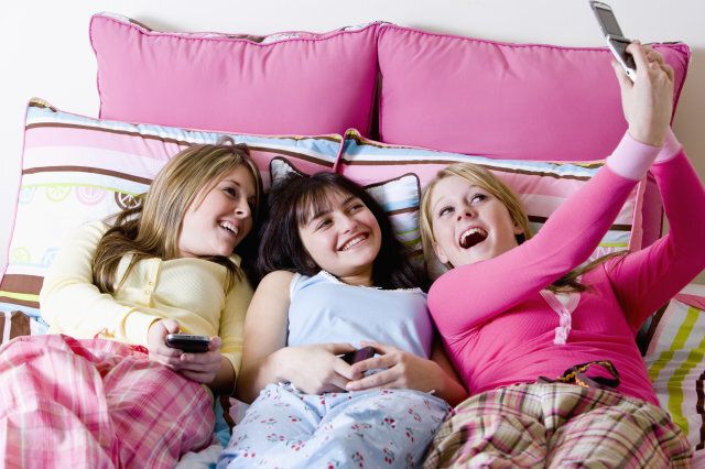 Girls taking picture in bed