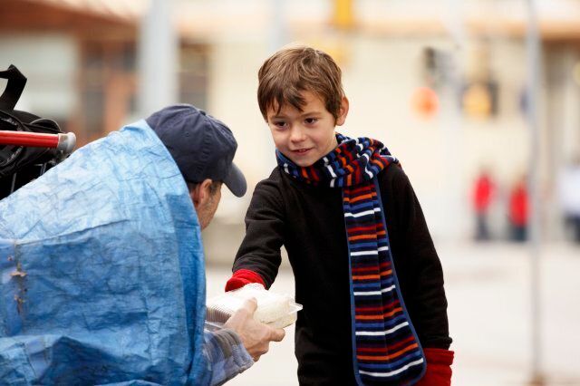 Child giving homeless man food