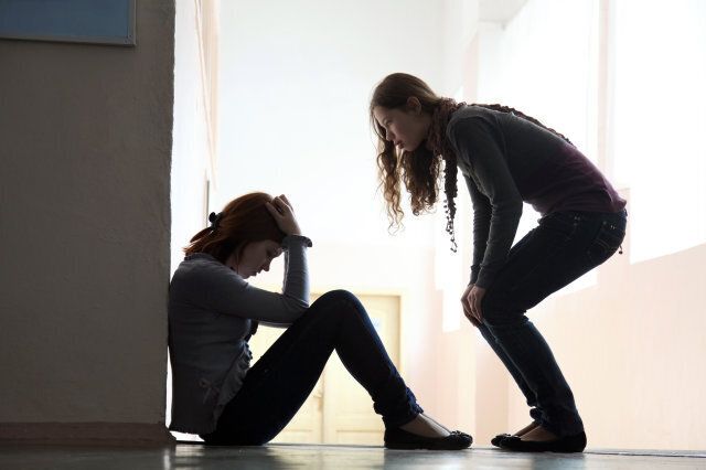 Teen girl offers to help her friend crying on the floor. silhouette