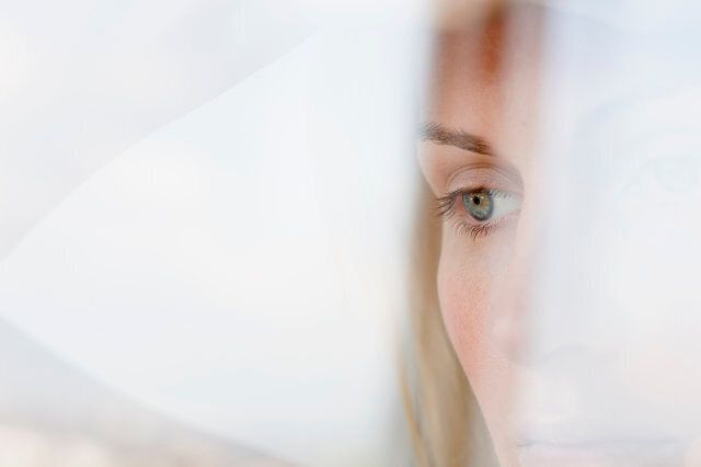 A serious woman looking contemplatively out a window