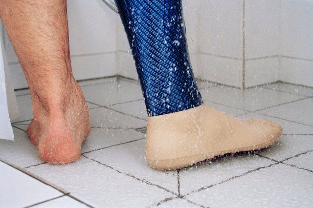 Low section of man showering with prosthetic leg