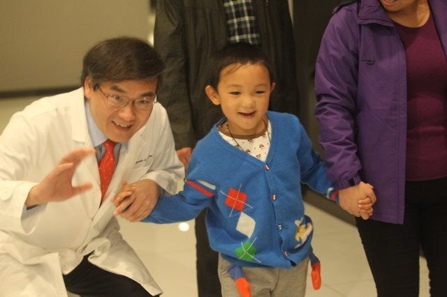 SHENZHEN, CHINA - DECEMBER 12: (CHINA OUT) Eye specialist Dr Dennis Lam Shun-chiu (L) and 6-year-old Guo Bin attend a farewell party at C-Mer (Shenzhen) Dennis Lam Eye Hospital on December 12, 2013 in Shenzhen, China. Guo Bin, who had his eyes gouged out by an attacker in August in Shanxi province, was discharged from hospital after successful orbital implants surgery, restoring his appearance but not his sight. (Photo by ChinaFotoPress/ChinaFotoPress via Getty Images)