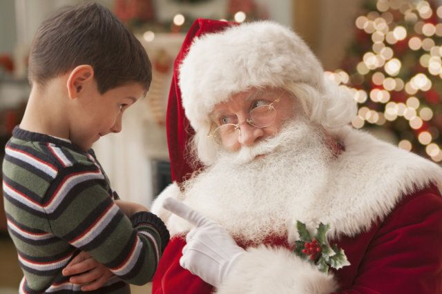 Santa lecturing Caucasian boy