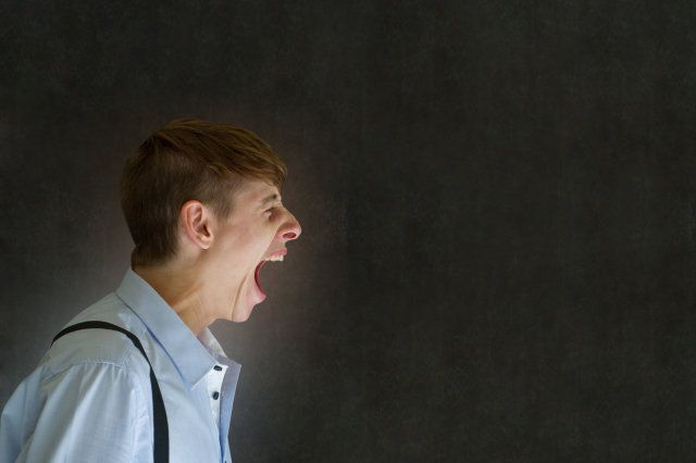 Angry big mouth man teacher, salesman, student or businessman shouting on blackboard background