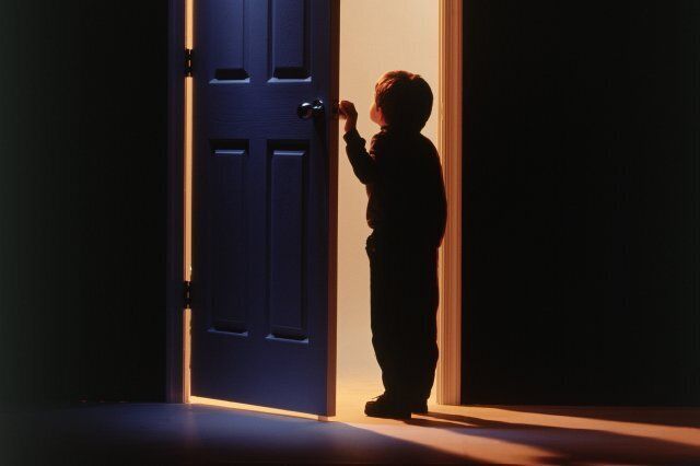 Little boy holding door