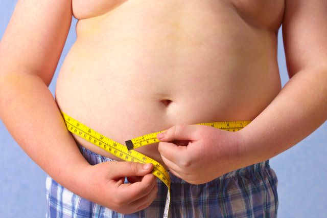 Overweight 12 year old boy measuring himself