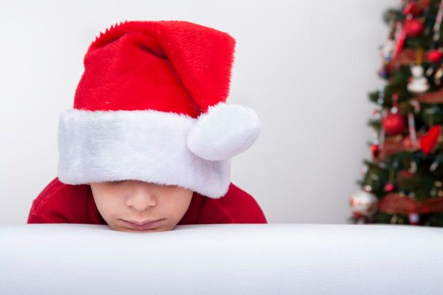 Christmas-Bored boy wearing santa's hat