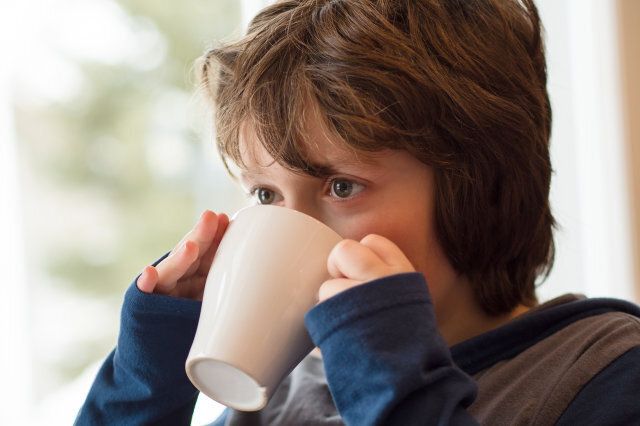 young boy drinking a hot...