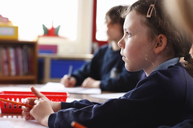 schoolgirl sitting attentively at her desk