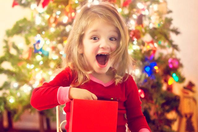 Girl surprised after opening Christmas gift.