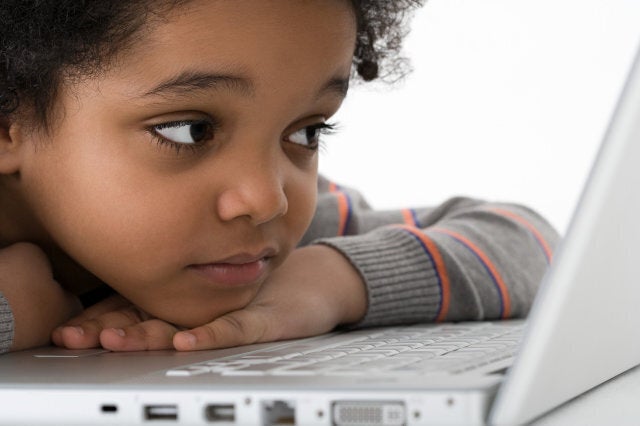 Boy leaning on laptop