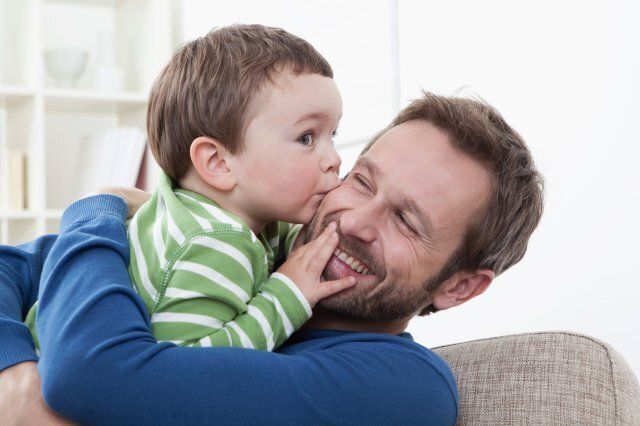 Son (2-3 Years) kissing his father, smiling