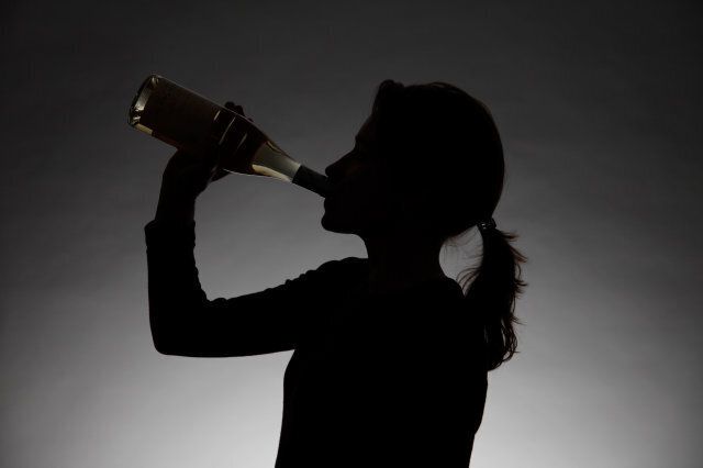 Woman drinking alcohol. Symbol: alcohol abuse, addiction