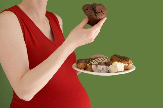 Pregnant woman eating cakes