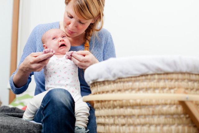 Mother holding upset newborn daughter