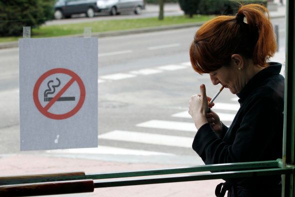 A woman lights a cigarette outside a cafe in Burgos on January 2, 2011 following the introduction of a new law today banning smoking in all bars, restaurants and public places. The new law bans smoking in all enclosed public spaces, including bars, restaurants and nightclubs and makes it illegal to smoke in children's parks or anywhere on school or hospital grounds.AFP PHOTO/CESAR MANSO (Photo credit should read CESAR MANSO/AFP/Getty Images)