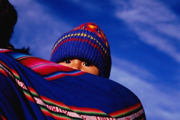 Bolivia, La Paz, young child wrapped in cloth on mother's back
