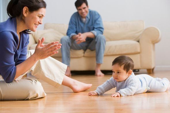 Mother clapping with baby on floor