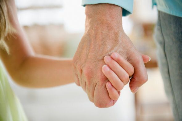 Grandma and granddaughter holding hands, close up