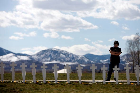 Garrett Bentley looks at a display of crosses for the 13 victims of the massacre at Columbine High School to mark the 10th anniversary of the killings near the Columbine Memorial in the southwest Denver suburb of Littleton, Colo., on Monday, April 20, 2009. (AP Photo/Jack Dempsey)