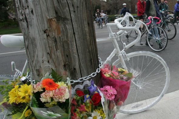 cyclist memorial RB 03 04-27-06 two memorials for cyclists killed on the roads SEE ORIGINAL PHOTO REQUEST held by Advocacy for Respect for Cyclist . the memorial was held at Cortleigh and Avenue Rd were a ghost cycle , painted white marks the spot were one cyclist was killed , in this case Van Tol , have to check news stories . About 75 cyclists attended. Rob Van Tol hands to face the brother of one of the cylist killed placed a flower on the bike and pauses to remember his brother . he is accompanied by friend Luuk Promes who travelled from the Netherlands to lend support to the family . The group stood in one lane of Ave Rd for several minutes of Silence to remember the cyclists. (Photo by Ron Bull/Toronto Star via Getty Images)
