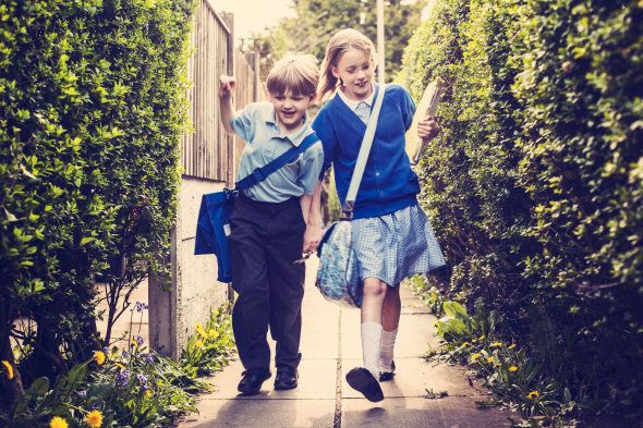 Two school children walking home from school together.
