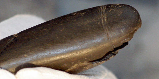 SCHELKLINGEN, Germany: Archaeologist Petra Kieselbach of Germany holds a 28,000 years old stone phallus which has been discovered in a cave in Baden-Wuertemberg in southern Germany, during a press conference in Schelklingen 25 July 2005. In assembling 14 stone fragments, found last year in the Hohle Fels cave, archeologists rebuilt the phallus, which is 20 centimeters (eight inches) long and three centimeters wide. AFP PHOTO DDP/MICHAEL LATZ GERMANY OUT (Photo credit should read MICHAEL