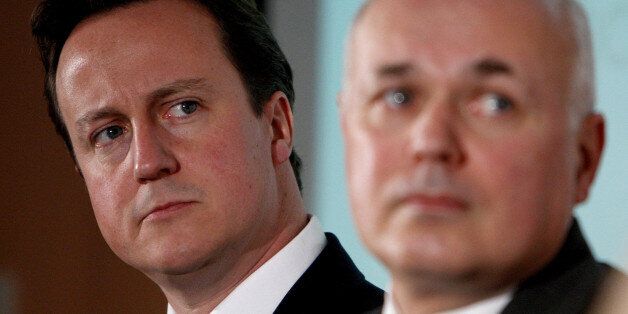 Conservative Party leader David Cameron, left, and former leader Iain Duncan Smith listen to information during the Breakthrough Britain campaign which bids to end social breakdown throughout the UK during a visit to Manchester.