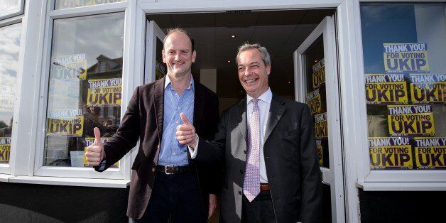 Newly-elected UK Independence Party (UKIP) MP Douglas Carswell (L) and party leader Nigel Farage pose for pictures at their local party office in Clacton-on-Sea, in eastern England, on October 10, 2014. Britain's anti-EU UK Independence Party won its first seat in the House of Commons Friday, sending jitters through Prime Minister David Cameron's Conservatives seven months before what is likely to be a tight general election. AFP PHOTO / LEON NEAL (Photo credit should read LEON NEAL/AFP/