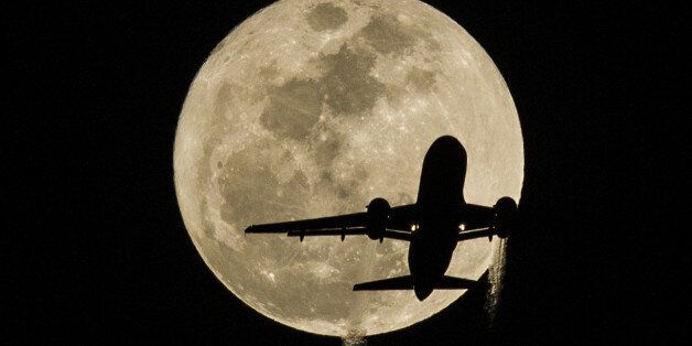 Feb. 3, 2015 - Los Angeles, California, U.S - An airplane approaching Los Angeles International Airport flies in front of the moon