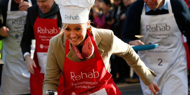 Media team competitor Sophie Ridge flips a pancake as she competes during the 2015 Parliamentary Pancake Race, Tuesday, Feb. 17, 2015. The race saw Lords, MPs and members of the parliamentary press corps racing to raise awareness of the need to support disable people, according to the organizers. (AP Photo/Lefteris Pitarakis)