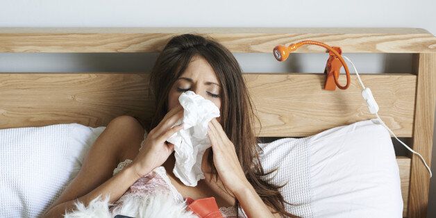 Young woman ill in bed with flu