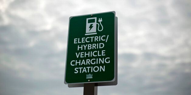 In this Thursday, Feb. 5, 2015 photo, a sign designates a parking space and charging station for electric vehicles outside a supermarket in Alpharetta, Ga. Electric vehicles are particularly popular in metro Atlanta, where electric vehicle owners can use highway lanes off-limits to solo drivers in a traditional car and a Nissan dealership runs regular radio ads claiming best in the nation sales of the plug-in Leaf. (AP Photo/David Goldman)